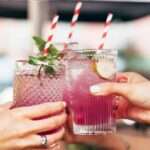 People Holding Cocktail Glasses