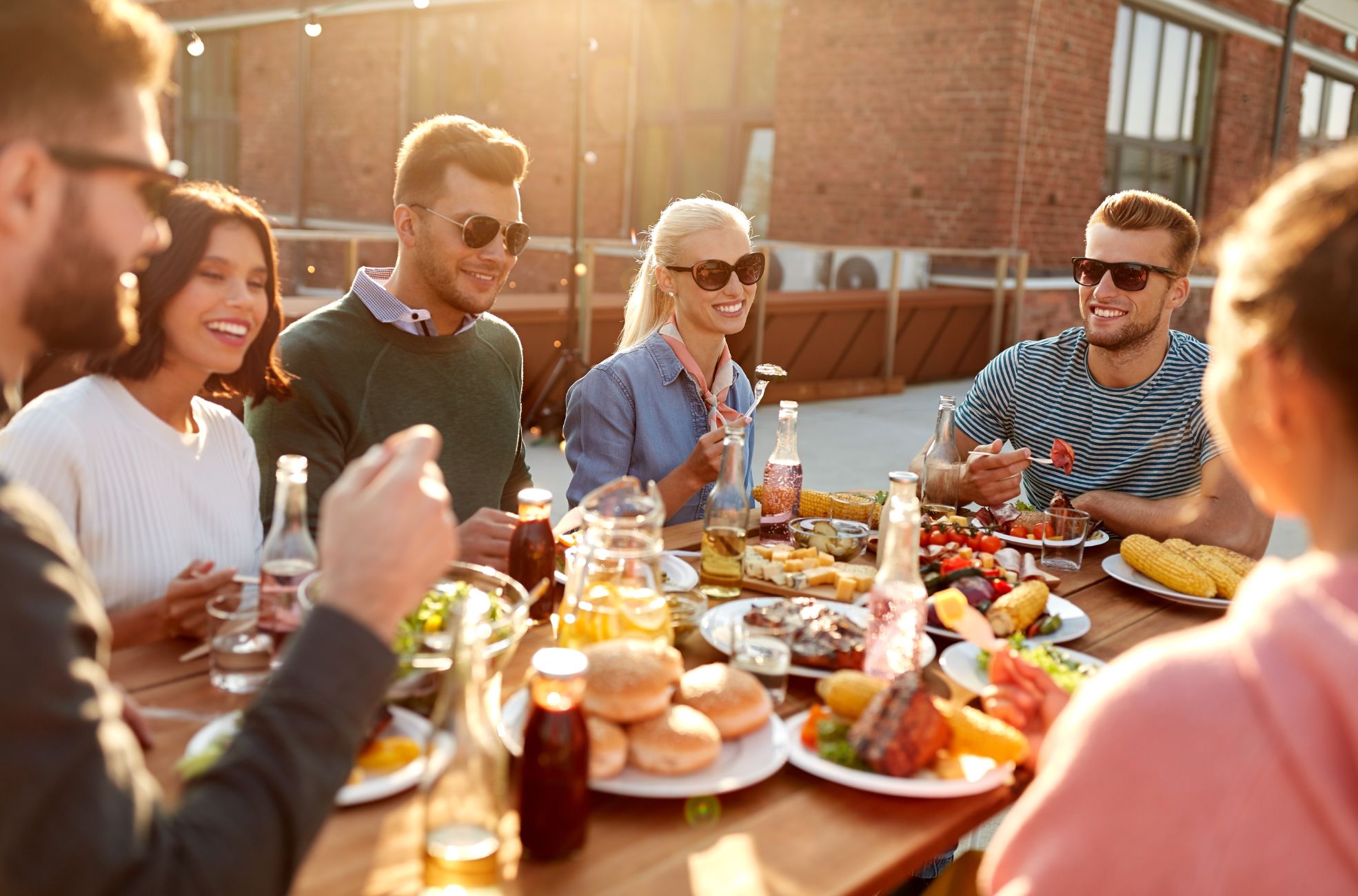 Adults Enjoying Food At Party Table