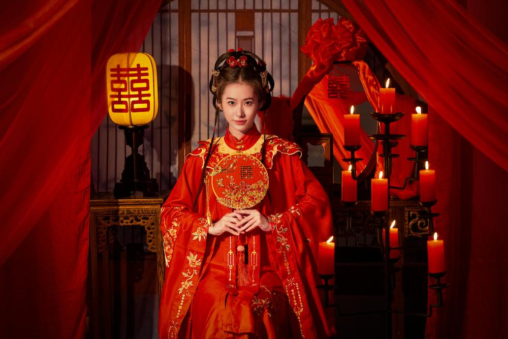 Asian girl dressed in traditional red outfit which signifies good luck in colour psychology