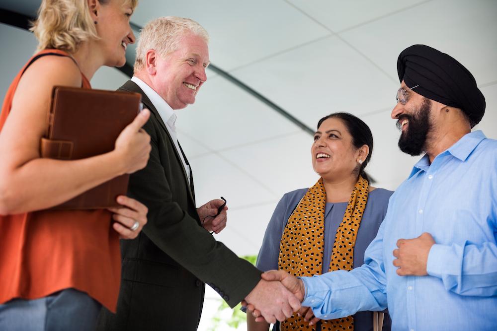 Two groups of business people shaking hands in celebration of an event collaboration