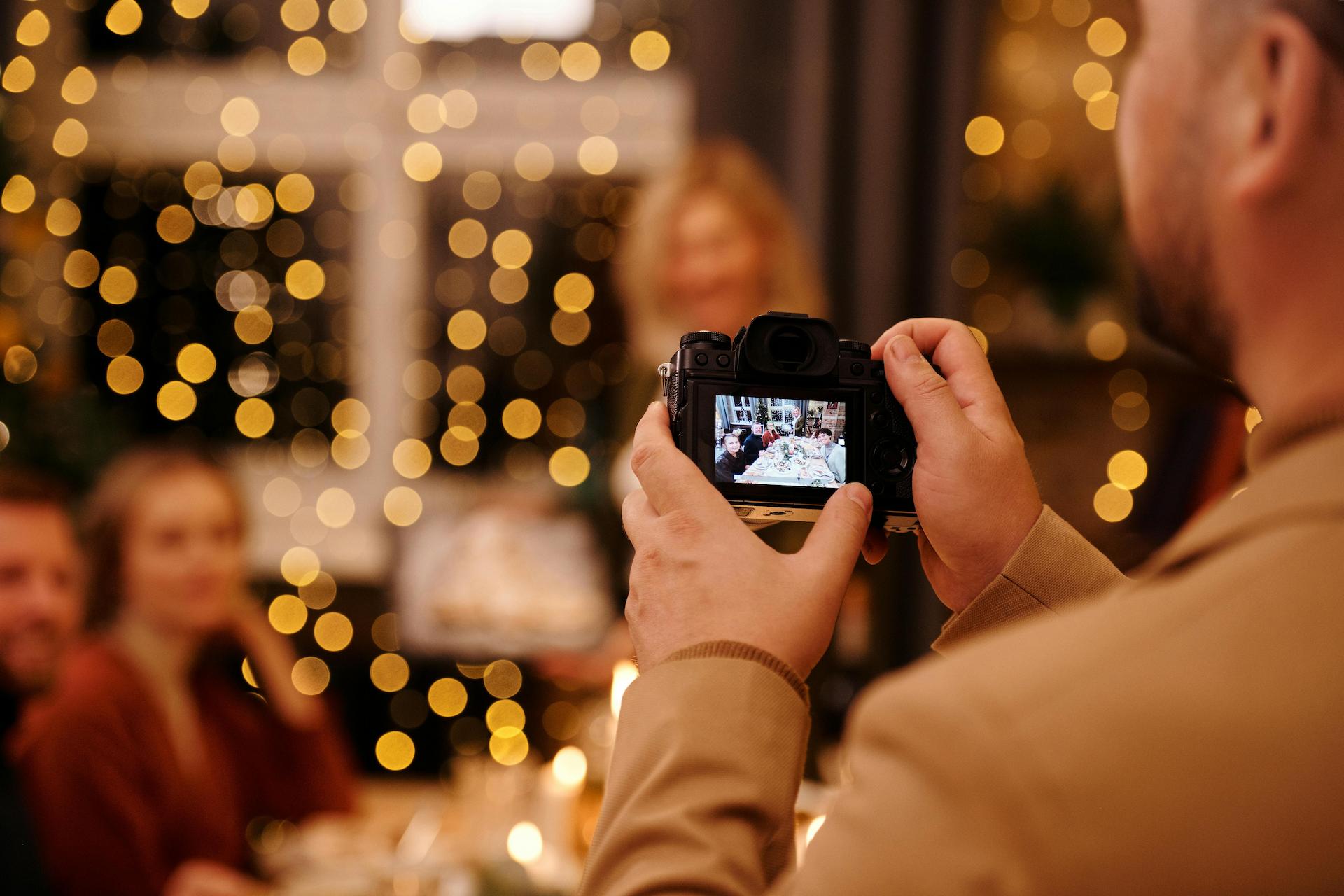 A man holding a camera and taking a photo of guests at the event while employing creative event photography ideas