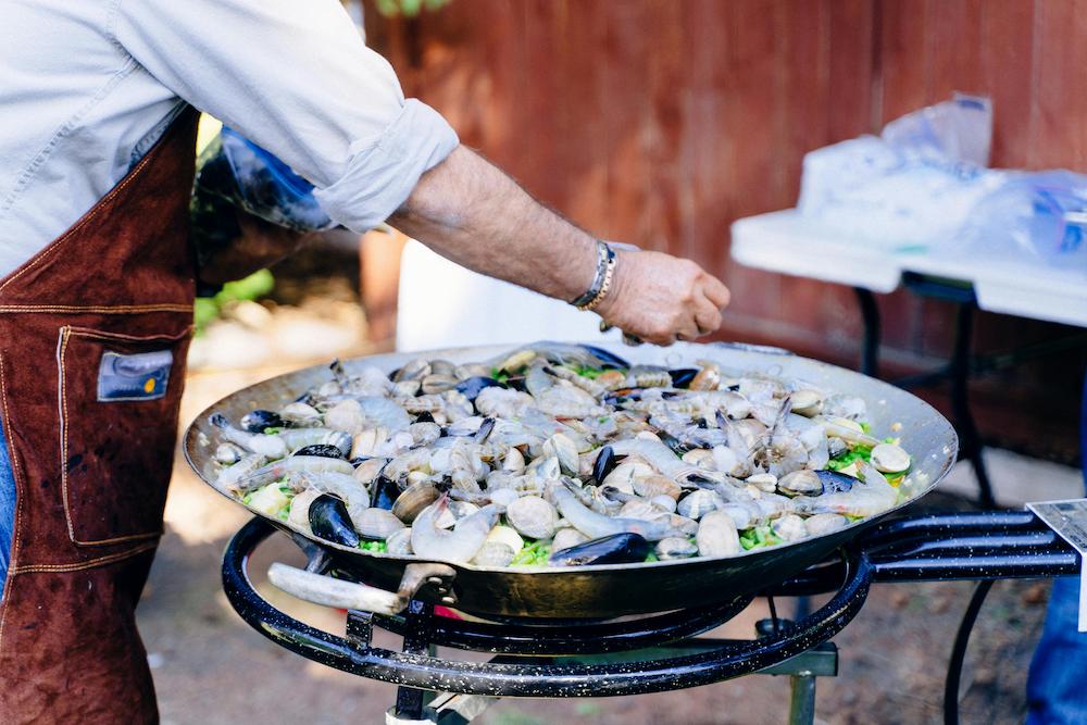 Live cooking demonstration of a chef preparing a seafood paella