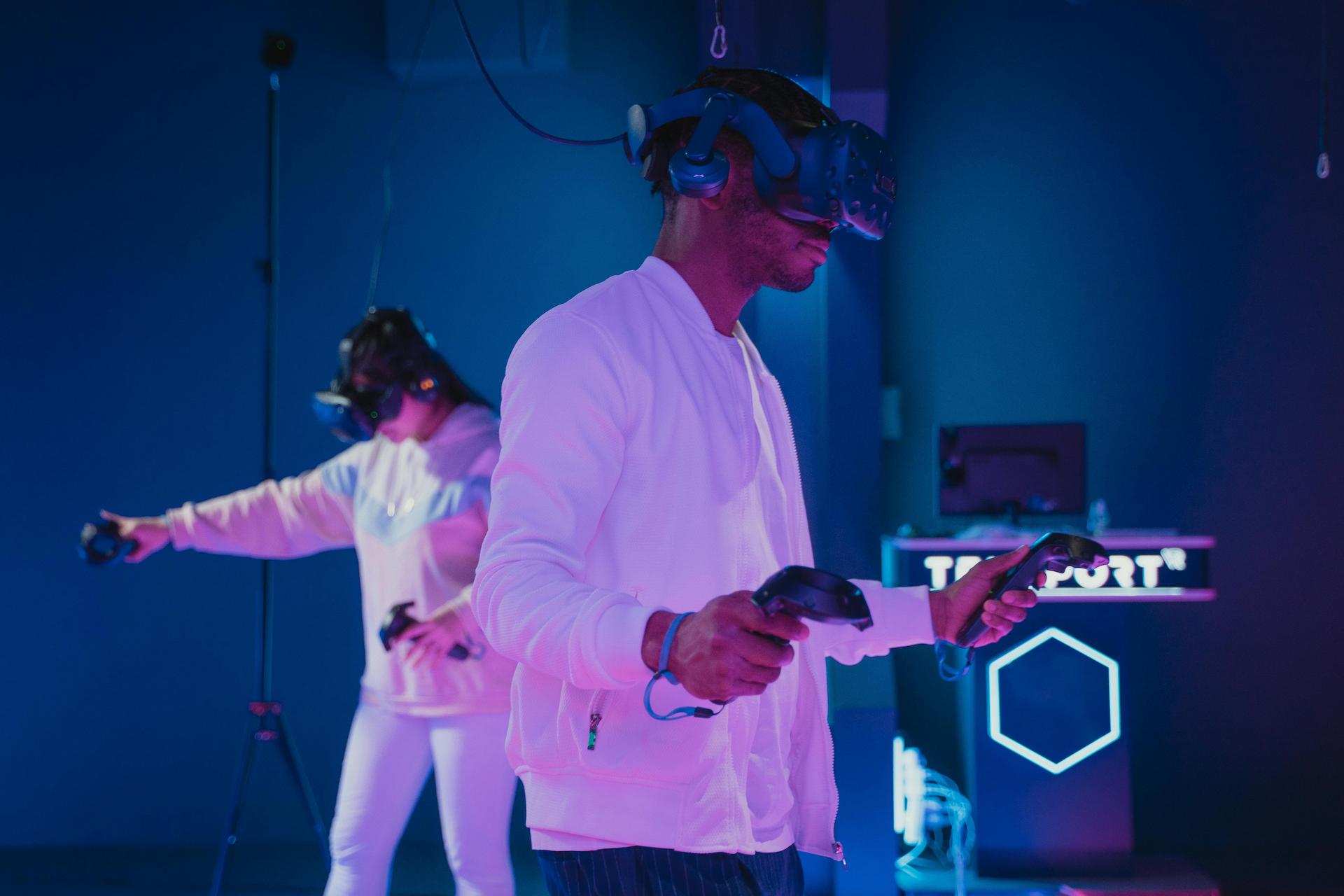 Two people in a dark space using virtual reality headsets as interactive entertainment