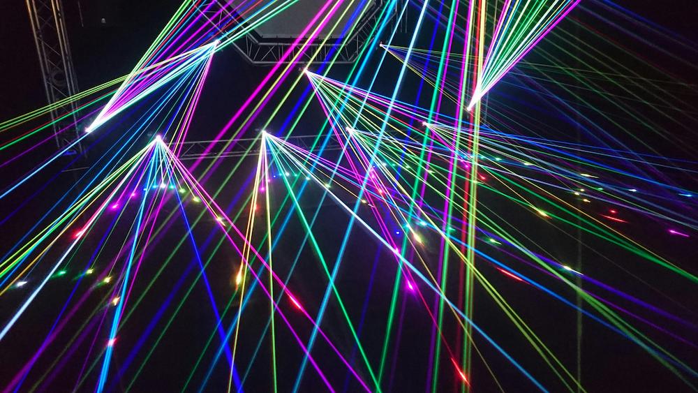 Light display with coloured beams of light as part of interactive entertainment at an event