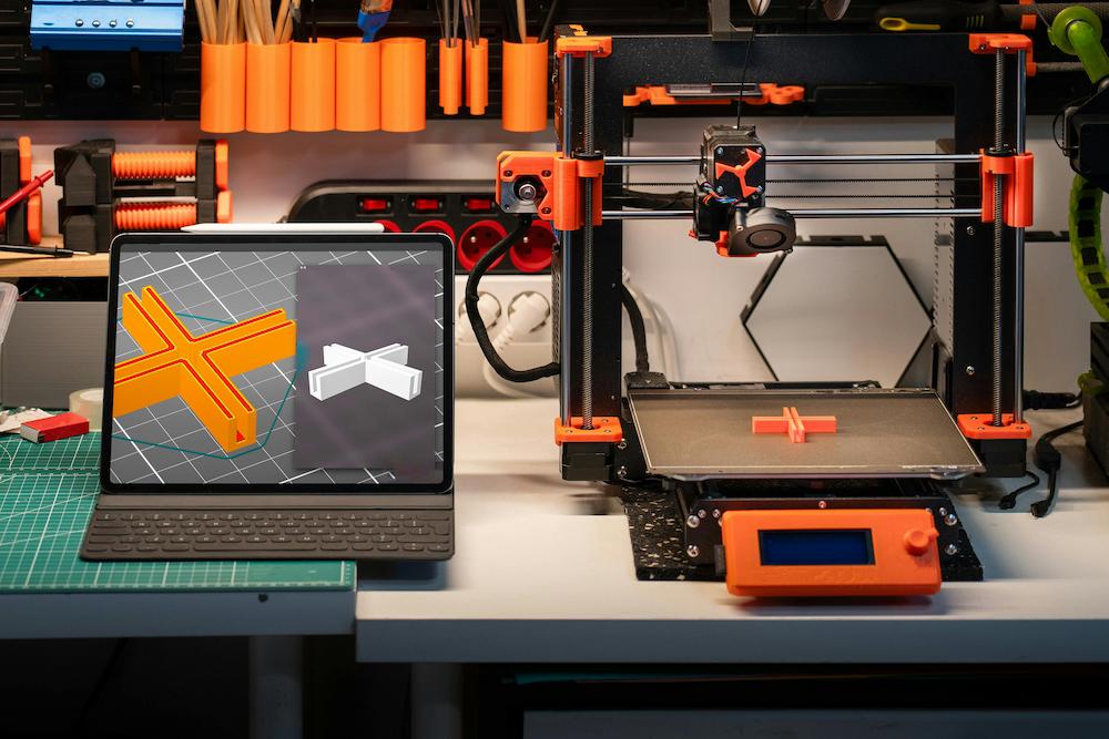 3D printer next to a computer with a design shown as part of interactive entertainment