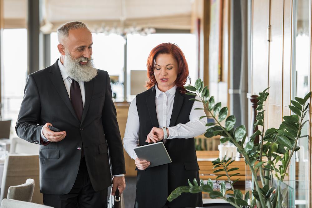 What is an event planner - a woman meeting with a client and looking at her watch to ensure the event is running on time