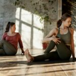 Two women doing yoga as part of wellness activities at a corporate event