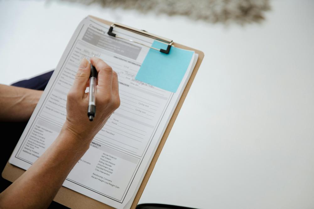 Close up of hand holding pen and filling out a survey on wellness activities offered at an event