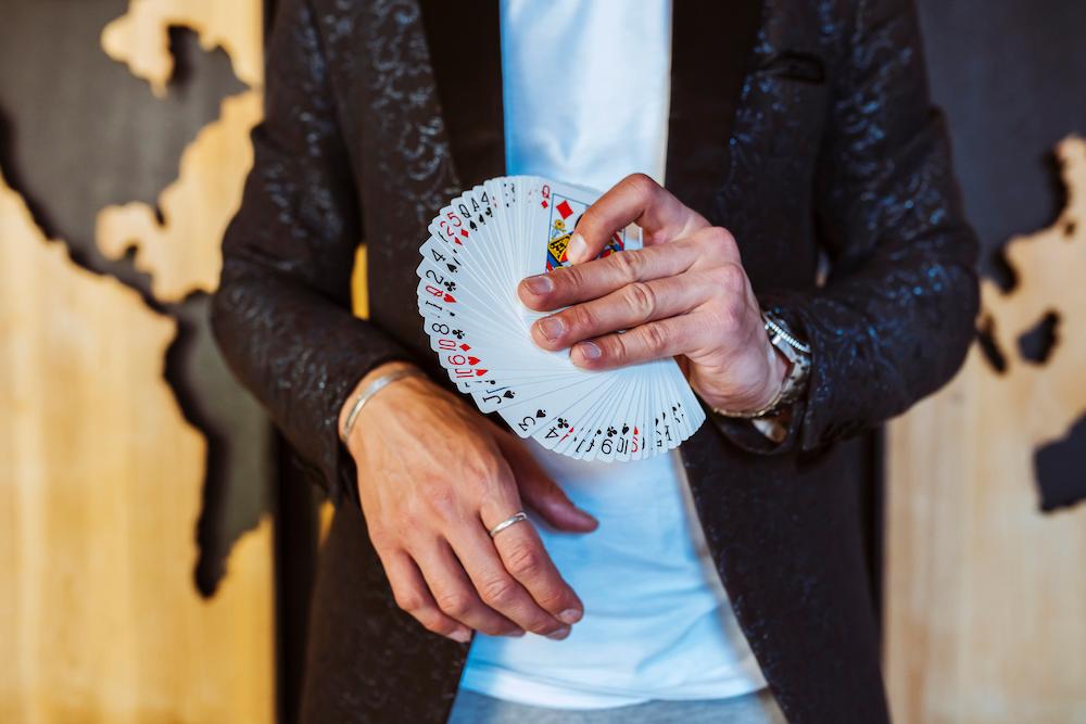 Close up shot of a magicians hands holding a pack of cards which is a great idea to have at your Christmas party in Brisbane