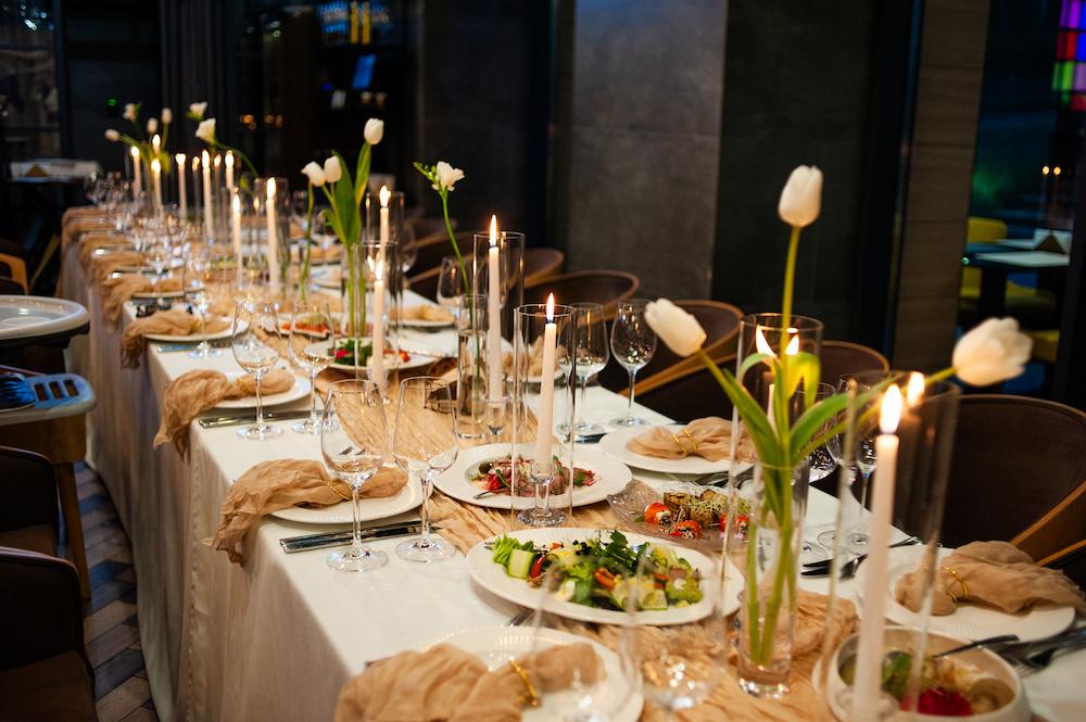 How to plan a banquet includes considering the table decorations as seen here with a white table cloth and flowers along the centre