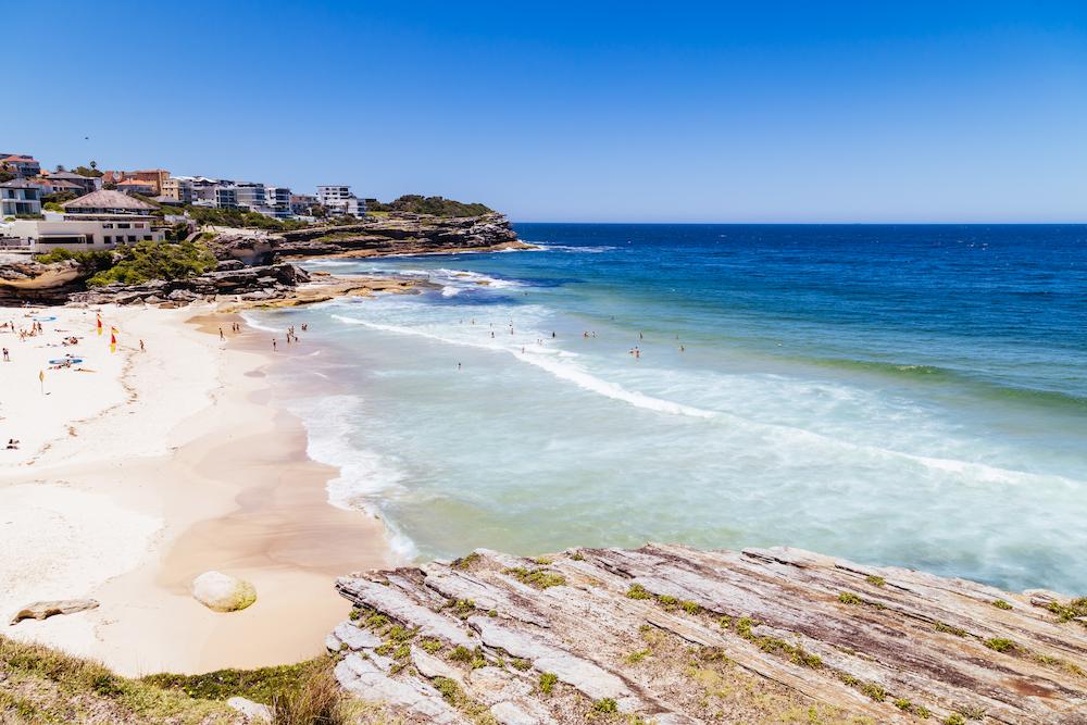 Beautiful Sydney beach on a sunny, blue sky day where you could meet for a casual work Christmas Party Ideas in Sydney