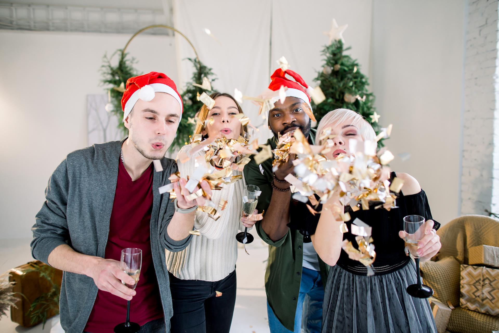 Work Christmas Party Ideas in Sydney include getting together like these four colleagues and drinking champagne while wearing santa hats