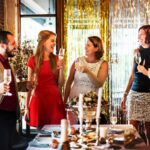 Work colleagues around a table cheersing with champagne classes at their work christmas party in Melbourne