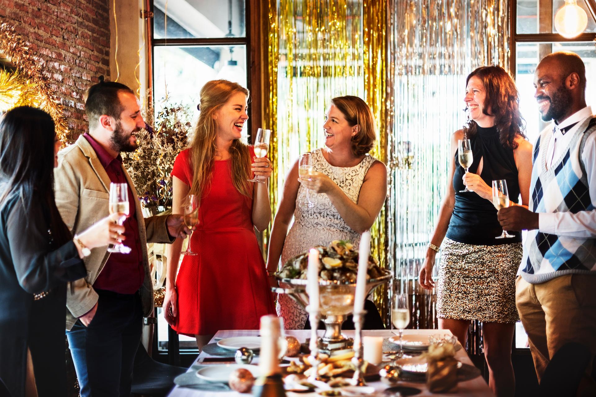 Work colleagues around a table cheersing with champagne classes at their work christmas party in Melbourne