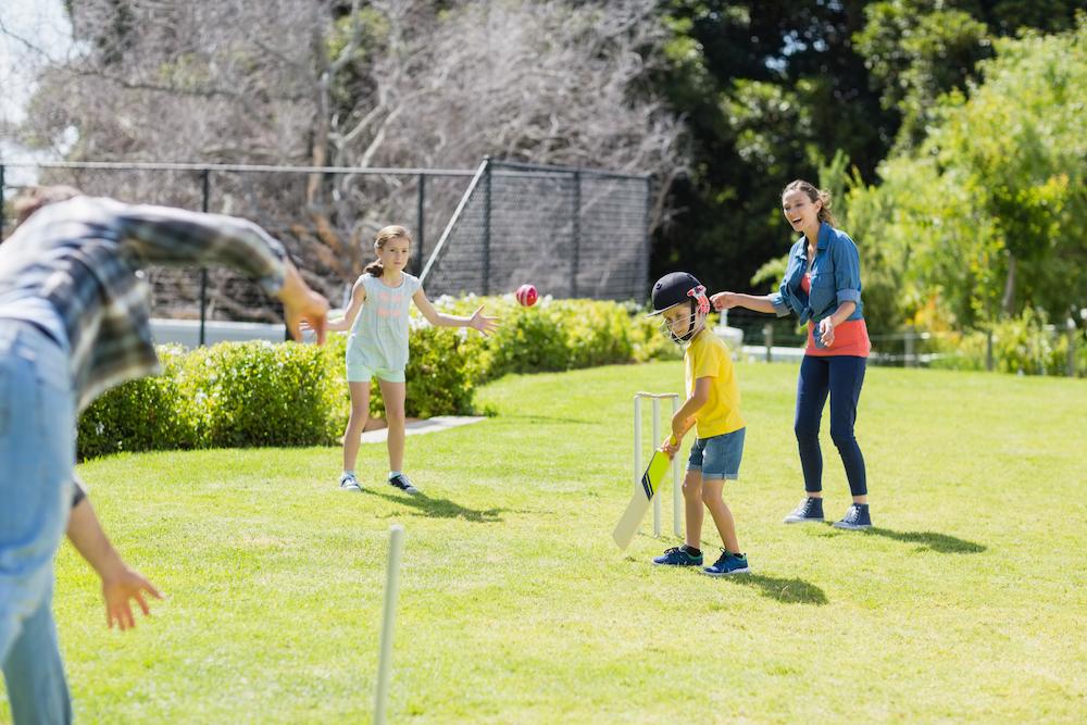 Family playing backyard cricket as part of an Australia day event