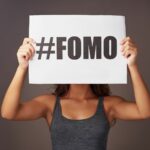 Woman Holding #FOMO Sign