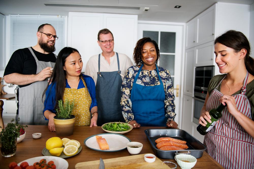 networking event ideas include a cooking class like this with people interacting in a kitchen